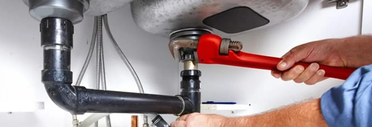 Garbage disposal repair technician tightening the sink drain and disposal connection in Scottsdale, AZ