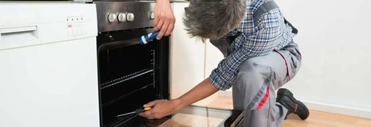 Oven repair technician inspecting and servicing an electric oven in Scottsdale, AZ